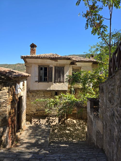 Free Charming old stone house with characterful architecture in a sunlit village alley. Stock Photo