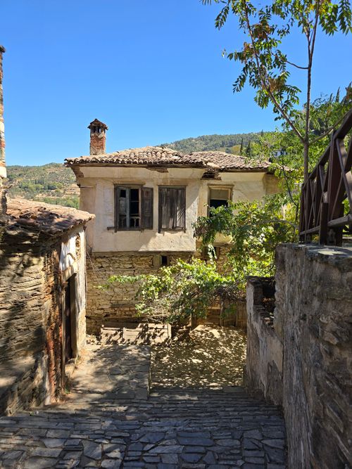 Free Quaint stone pathway leading to a rustic house surrounded by nature. Stock Photo