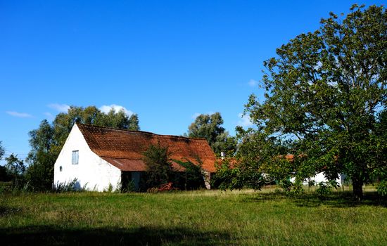 Idyllic farmhouse beneath a blue sky in La Panne, Belgium, showcasing Flemish architecture.