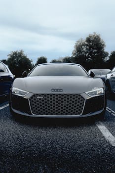 A modern Audi R8 car is prominently displayed in an outdoor parking lot, showcasing its sleek design.