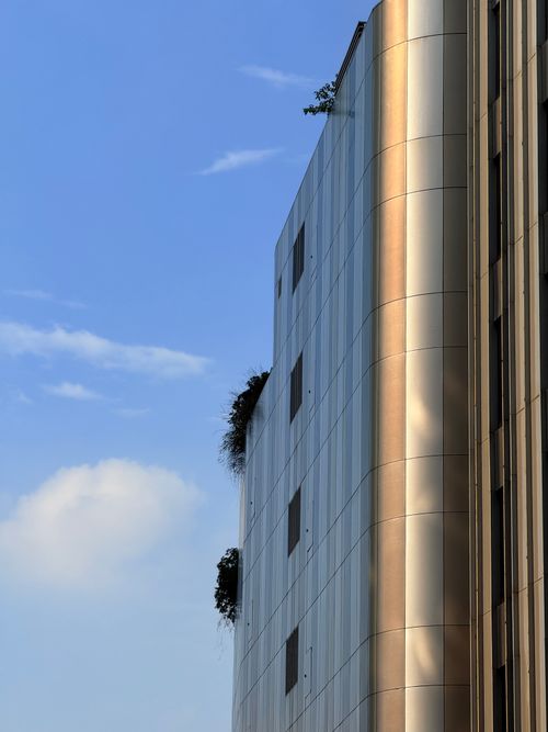 Free Sleek urban architecture with a vertical garden against a clear blue sky. Stock Photo