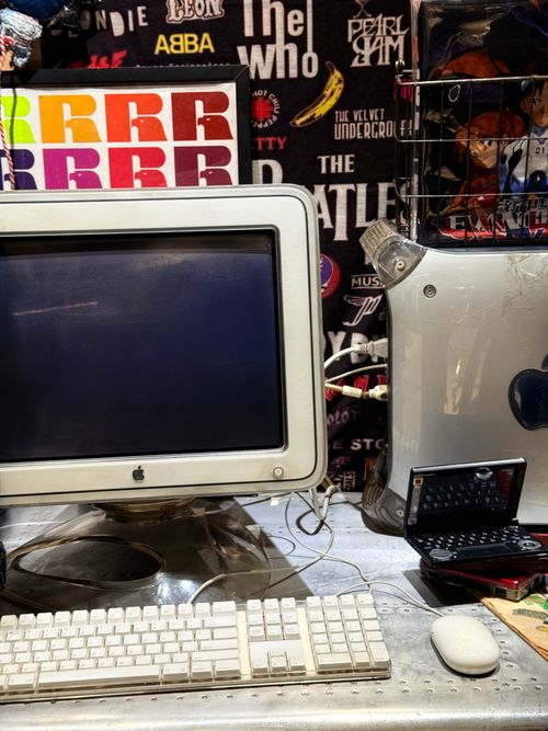 Free Classic Apple computer setup with vibrant retro band posters backdrop. Stock Photo