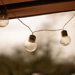 Clear round festoon bulbs strung under a pergola