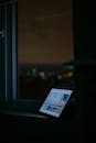 Tablet by Window with Night Cityscape View