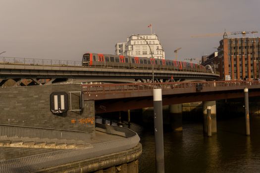A train crossing a bridge in urban Hamburg on a clear day, exemplifying Germany's architecture.