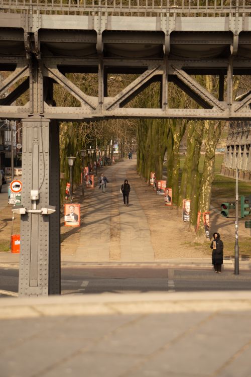 Free A scenic tree-lined walkway beneath a bridge in Hamburg, showcasing urban life. Stock Photo