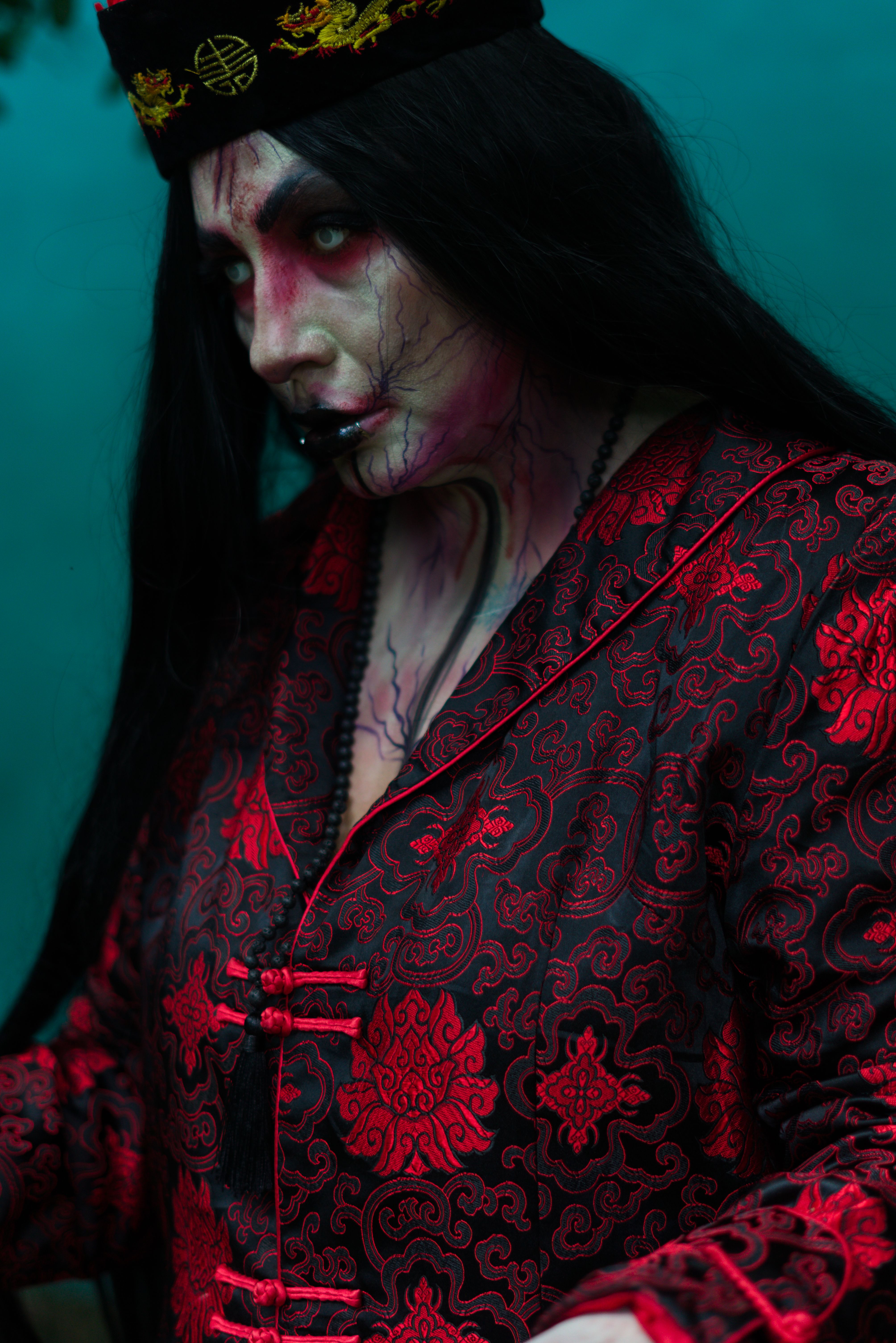 A dramatic portrait of a woman in ornate red clothing, exuding mystery.