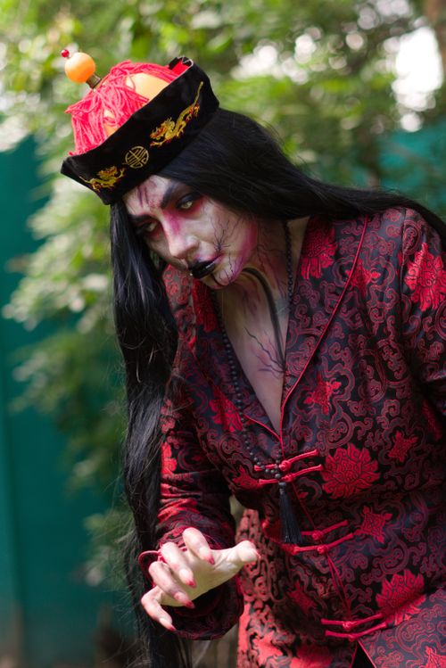 Free Spooky cosplay featuring a traditional Chinese vampire in ornate garments, captured outdoors. Stock Photo