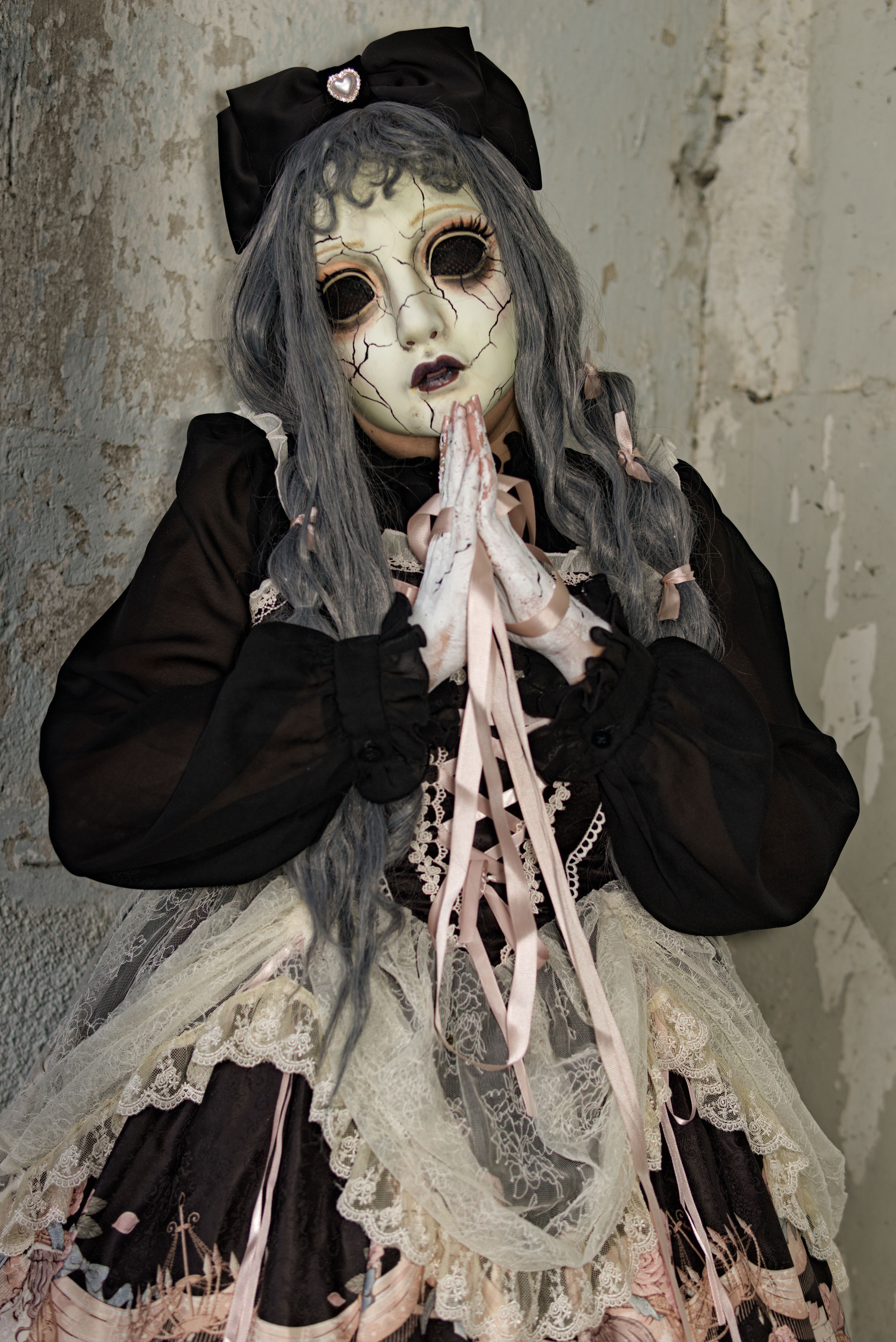 Eerie photo of a person in a doll-like costume inside an old, worn-out building.
