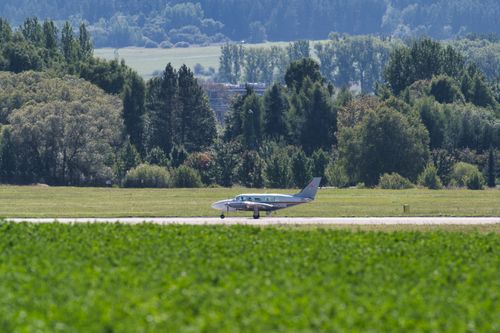 Free Small propeller aircraft on runway in lush forested landscape, Poprad, Slovakia. Stock Photo