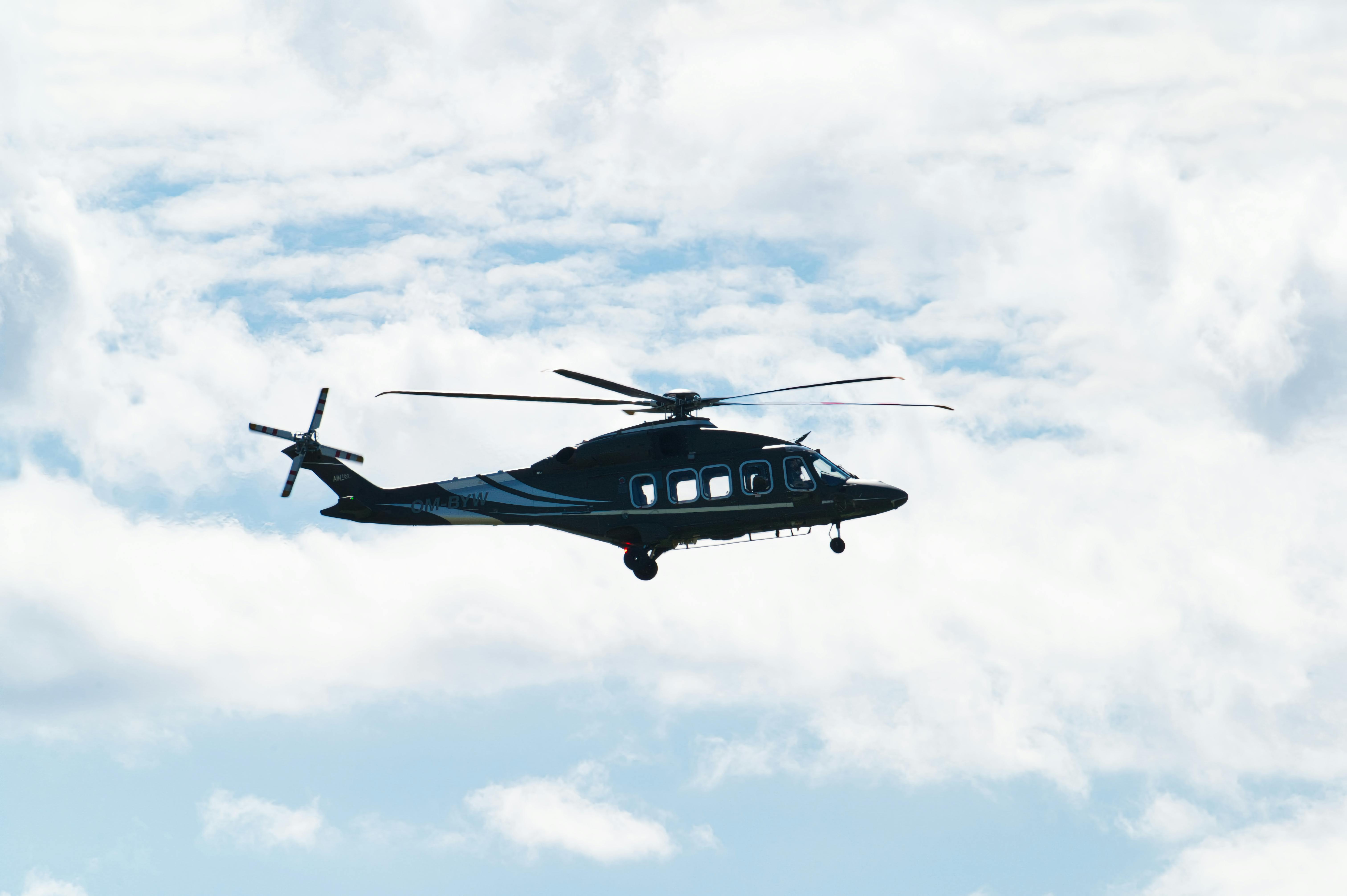 A helicopter soaring against a bright blue sky in Poprad, Slovakia.
