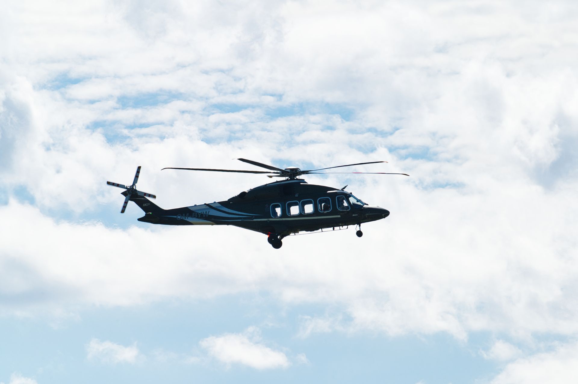 A helicopter soaring against a bright blue sky in Poprad, Slovakia.