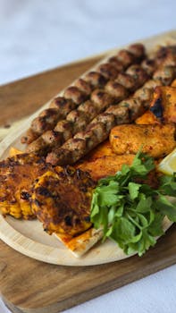 A mouth-watering platter of grilled kebabs, corn, and greens, perfect for summer BBQs.