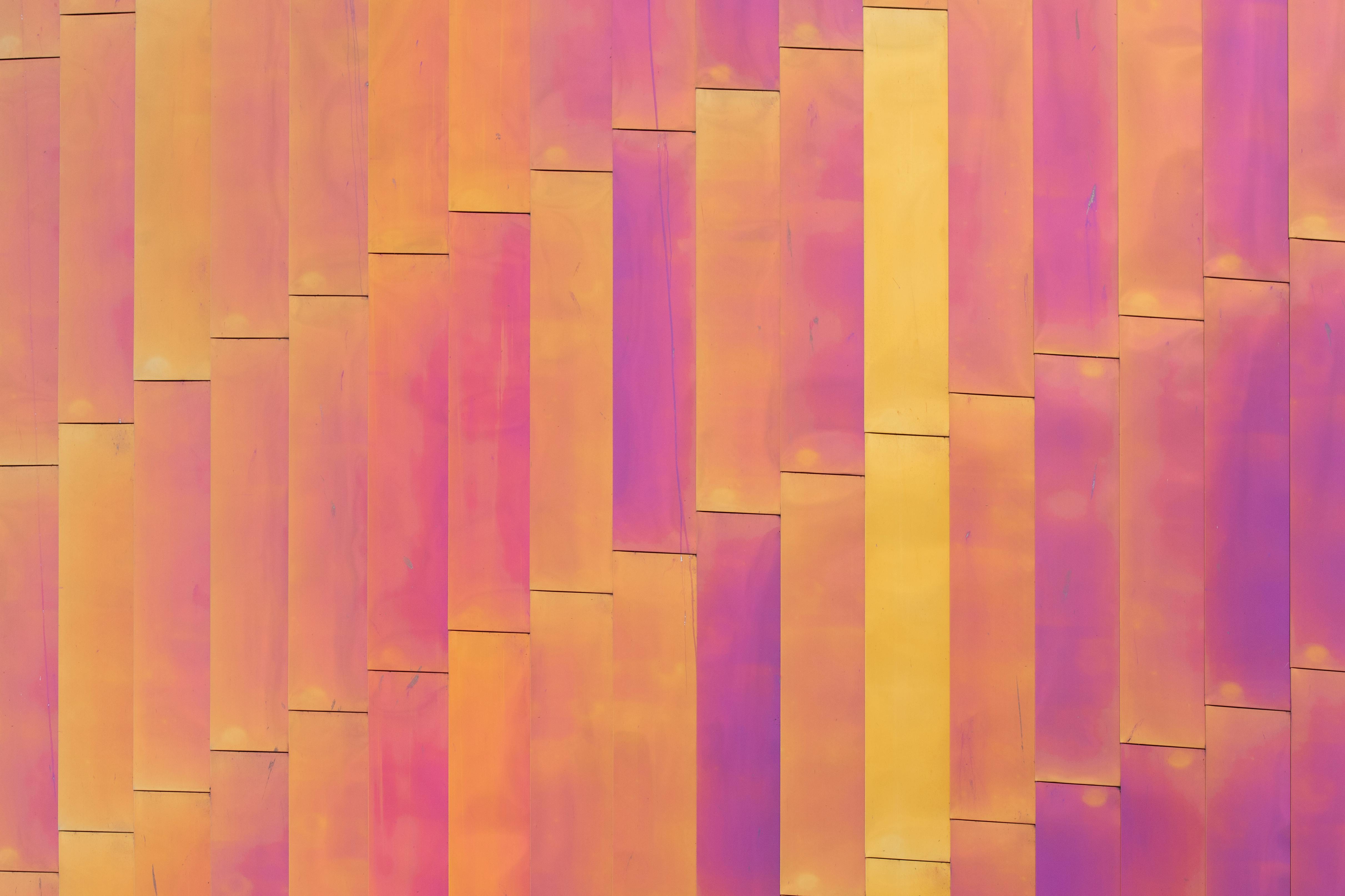 Close-up view of a vibrant multicolored metal facade with abstract geometric patterns.