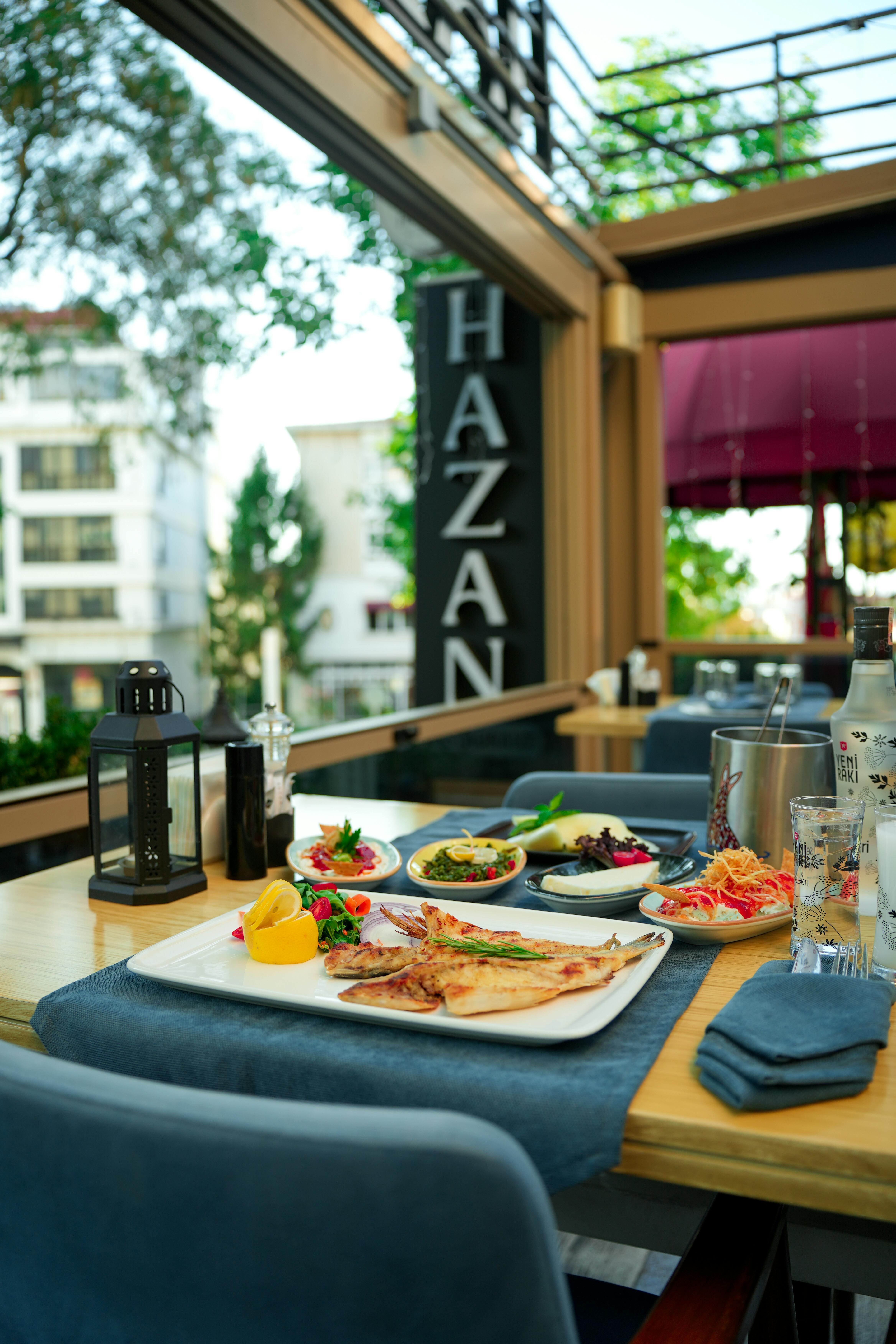 Outdoor dining setup with a spread of Mediterranean dishes at a restaurant patio.