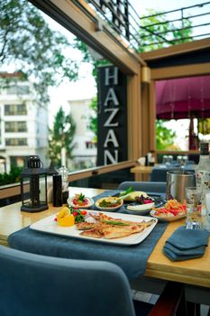 Outdoor dining setup with a spread of Mediterranean dishes at a restaurant patio. - Fotografer Sidoarjo
