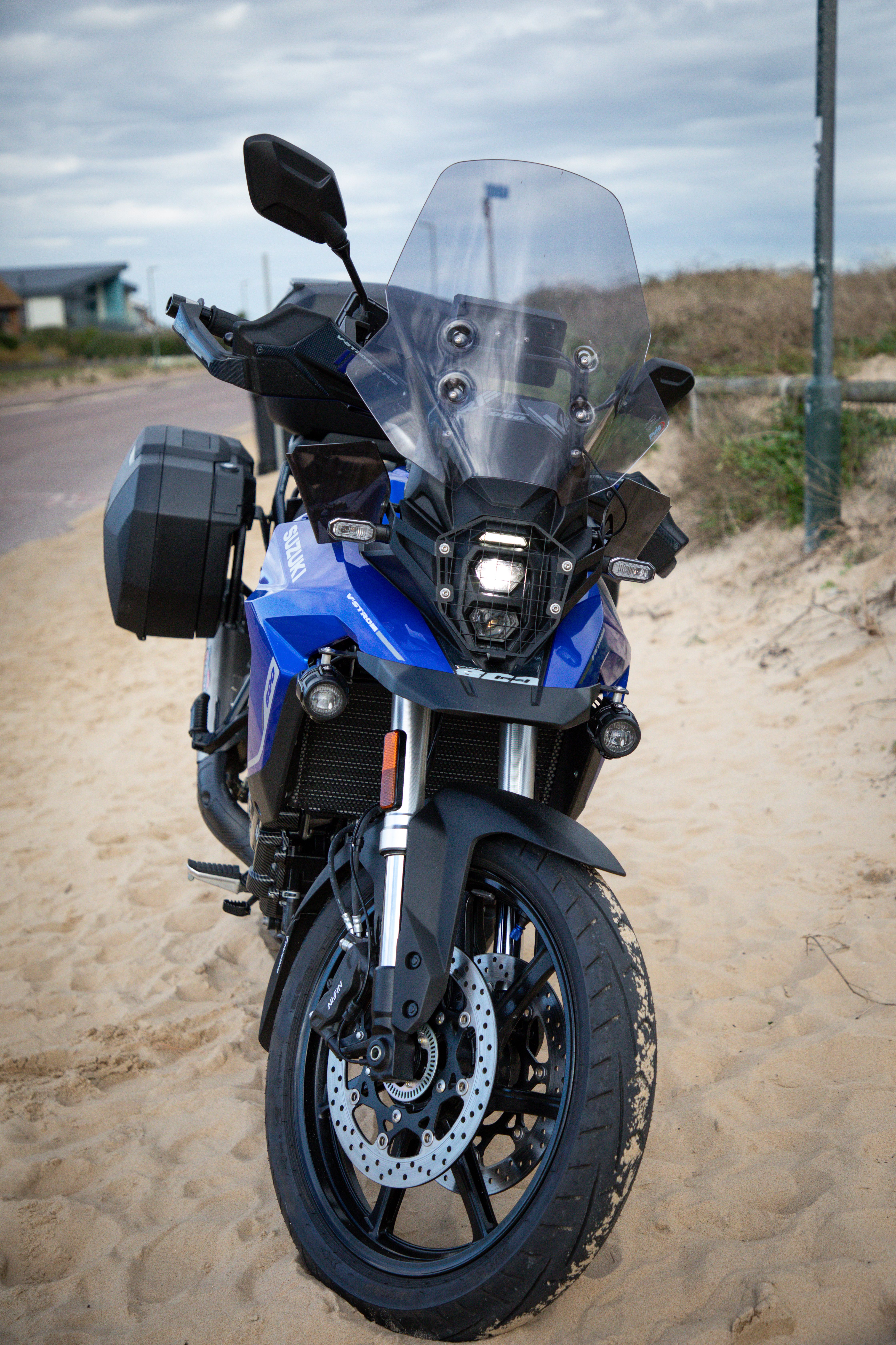 essai CFMOTO 450MT — vue trois-quarts avant garée sur un chemin de terre, en situation trail