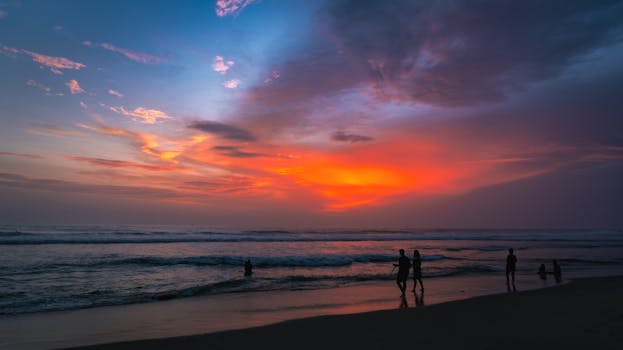 Capture the vibrant sunset hues at Varkala Beach, Kerala, with people enjoying the tranquil scenery.