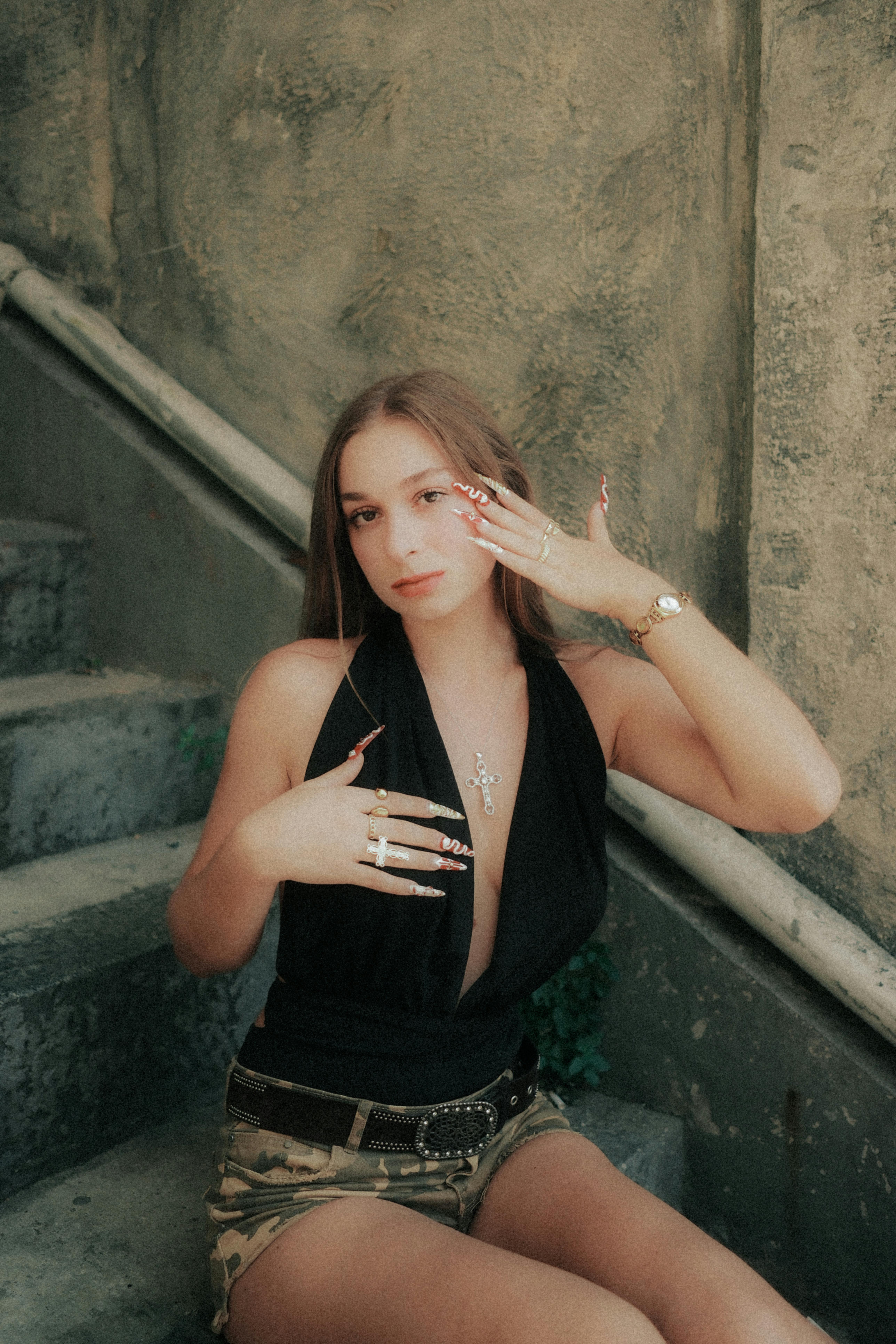 Bezpłatne Młoda kobieta pozuje na schodach, prezentując biżuterię w modnym miejskim stylu. Zdjęcie z galerii