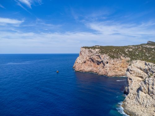 Free Breathtaking aerial view of a rocky cliffside in Sardinia, Italy, with vivid blue Mediterranean waters. Stock Photo