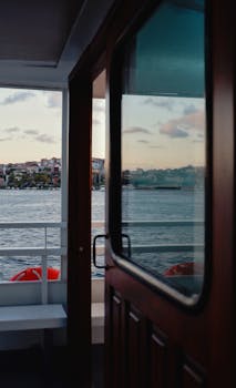 Serene view from a boat at sunset capturing city skyline and calm river.