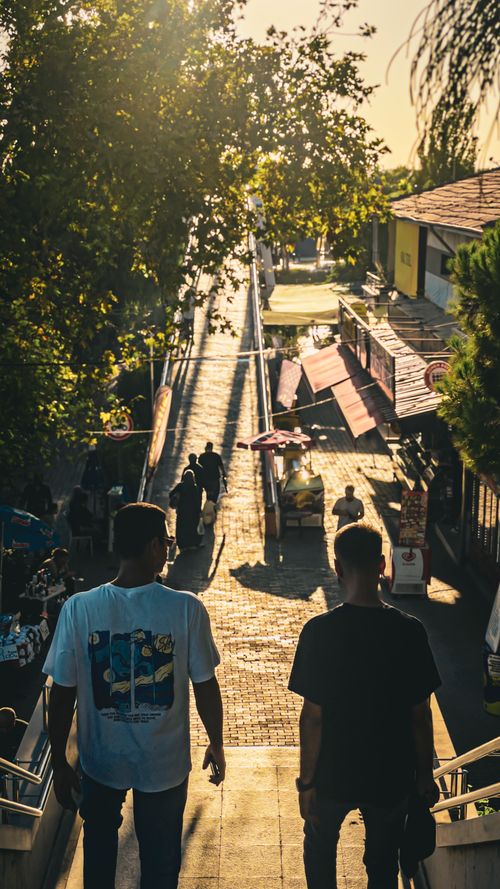 Free Two people walk down outdoor stairs during golden hour in İzmir, Türkiye. Stock Photo
