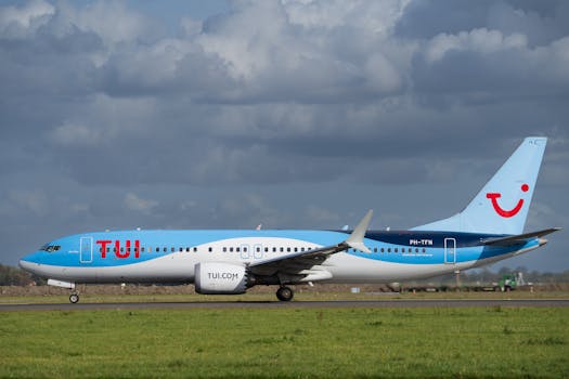 TUI Airlines jet taxiing on runway against cloudy sky, captured in daylight.