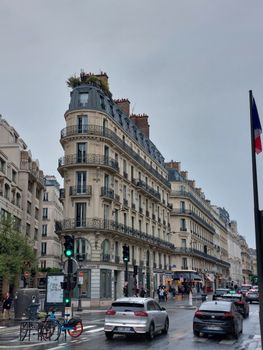 Explore classic Paris architecture on a rainy street in Île-de-France, France.