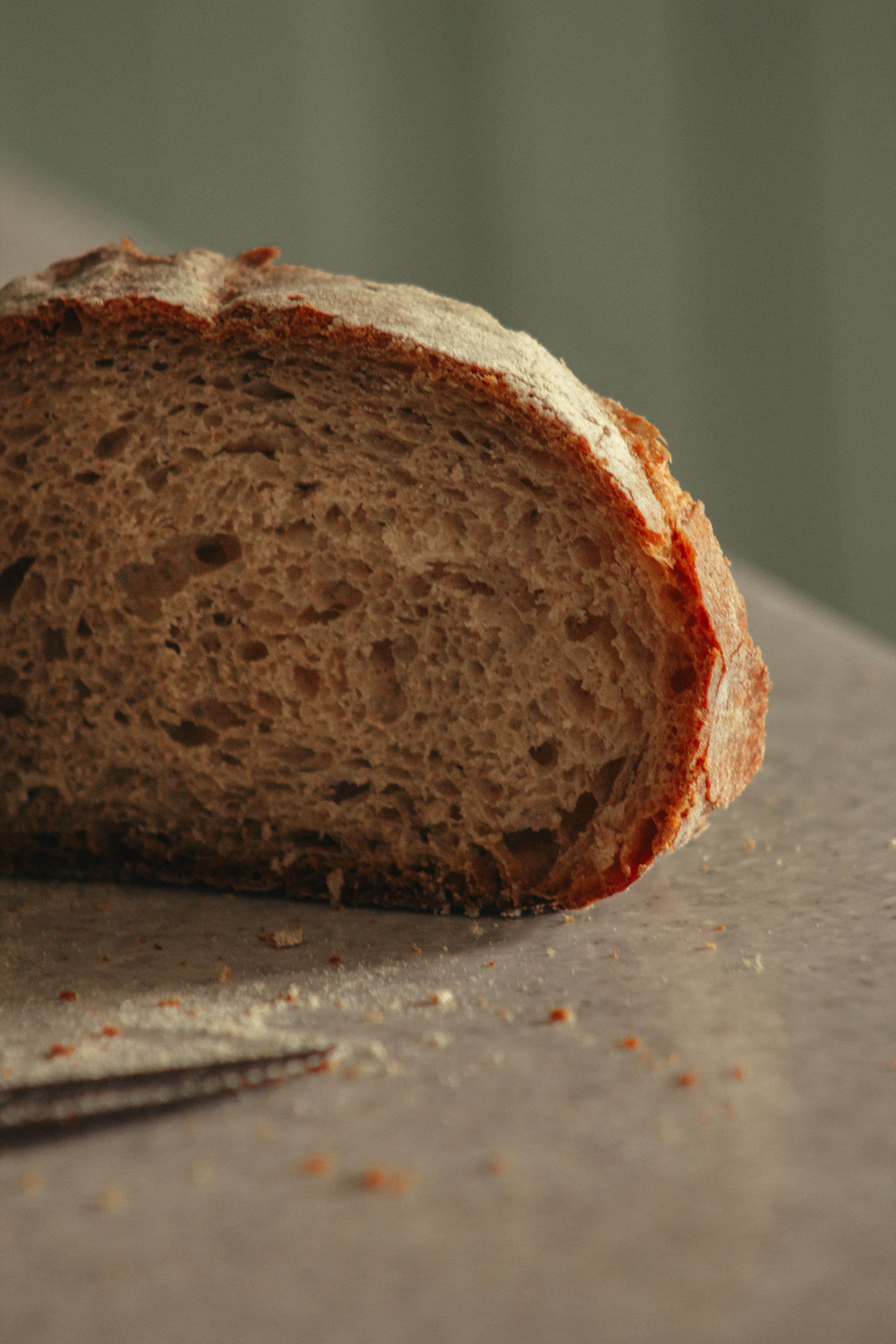 Close-up of a rustic slice of artisan bread on a kitchen counter.
