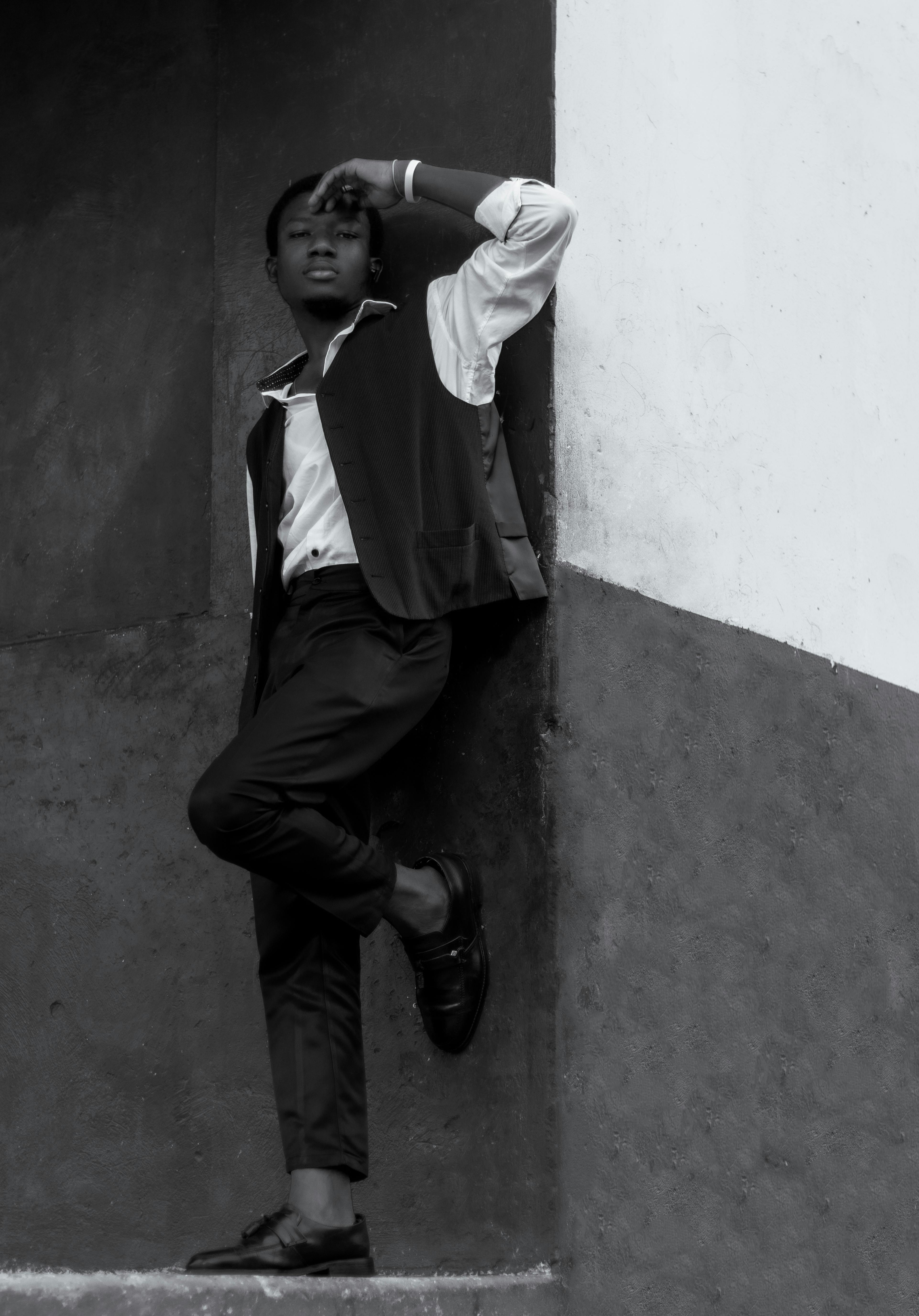 De franc Retrat monocrom d'un jove elegant posant contra una paret. Foto d'estoc