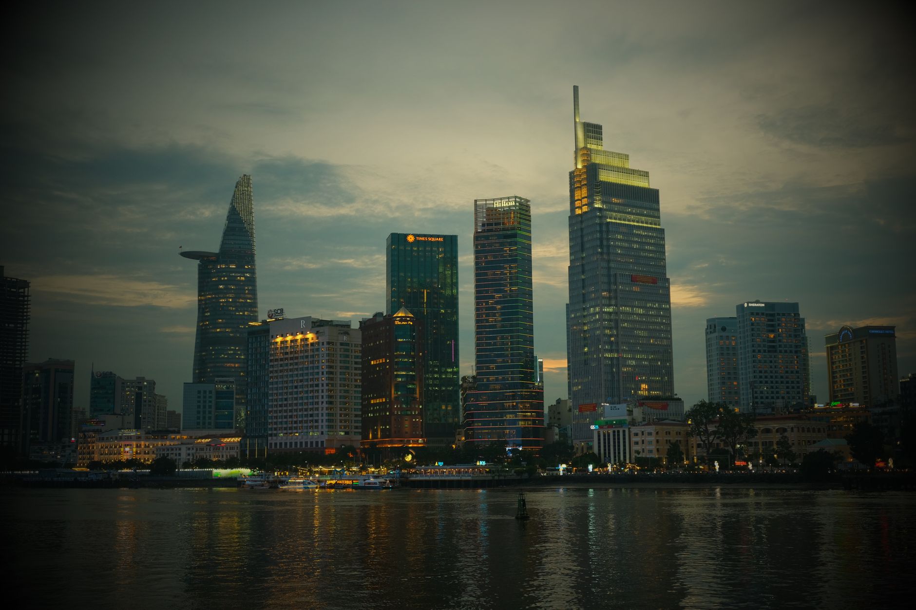 Stunning view of Ho Chi Minh City's illuminated skyline at dusk with iconic buildings.