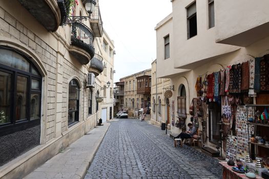 Quiet cobblestone street lined with historic buildings and shops in a picturesque old town.