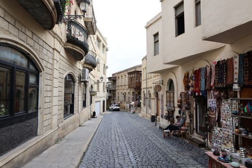 Free Quiet cobblestone street lined with historic buildings and shops in a picturesque old town. Stock Photo