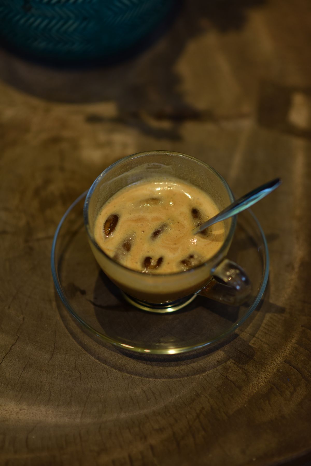 A creamy iced coffee served in a glass cup on a wooden table