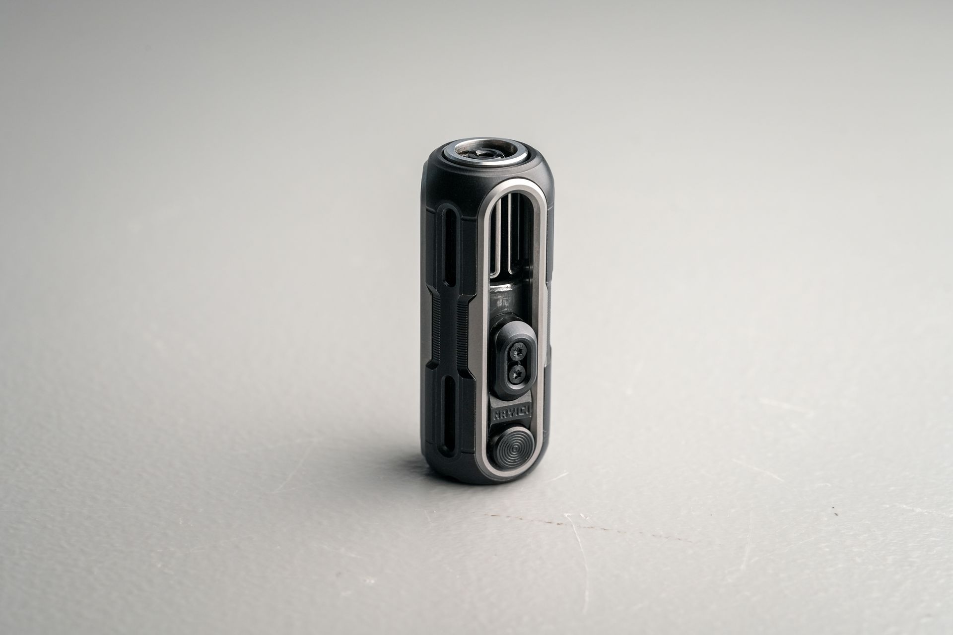 Detailed view of a sleek, compact action camera on a neutral background, showcasing its modern design.