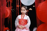 Portrait of a young girl in traditional attire celebrating Mid-Autumn Festival with lanterns and festive decor.