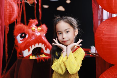 Free Smiling girl in traditional attire at a vibrant Lunar New Year celebration with red lanterns. Stock Photo