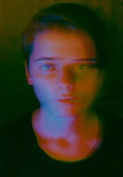 一幅男子肖像在戏剧性的彩色灯光效果下，呈现出模糊的艺术外观