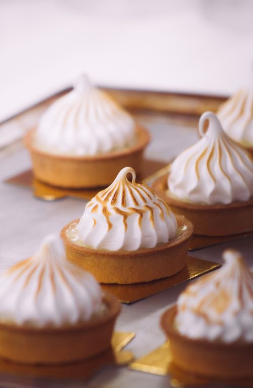 Free Mouthwatering lemon meringue tarts with golden peaks on a baking tray. Stock Photo