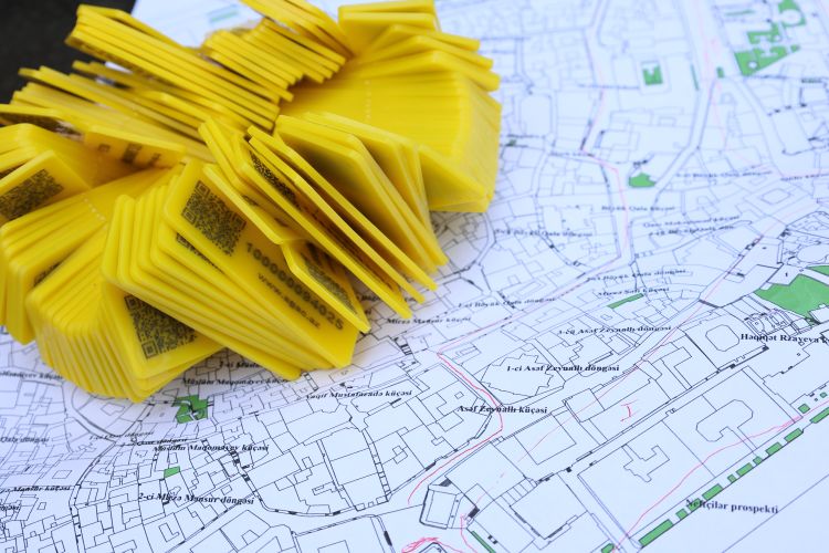 Pila de marcadores de código QR amarillos colocados en un mapa detallado para seguimiento de ubicación y navegación.