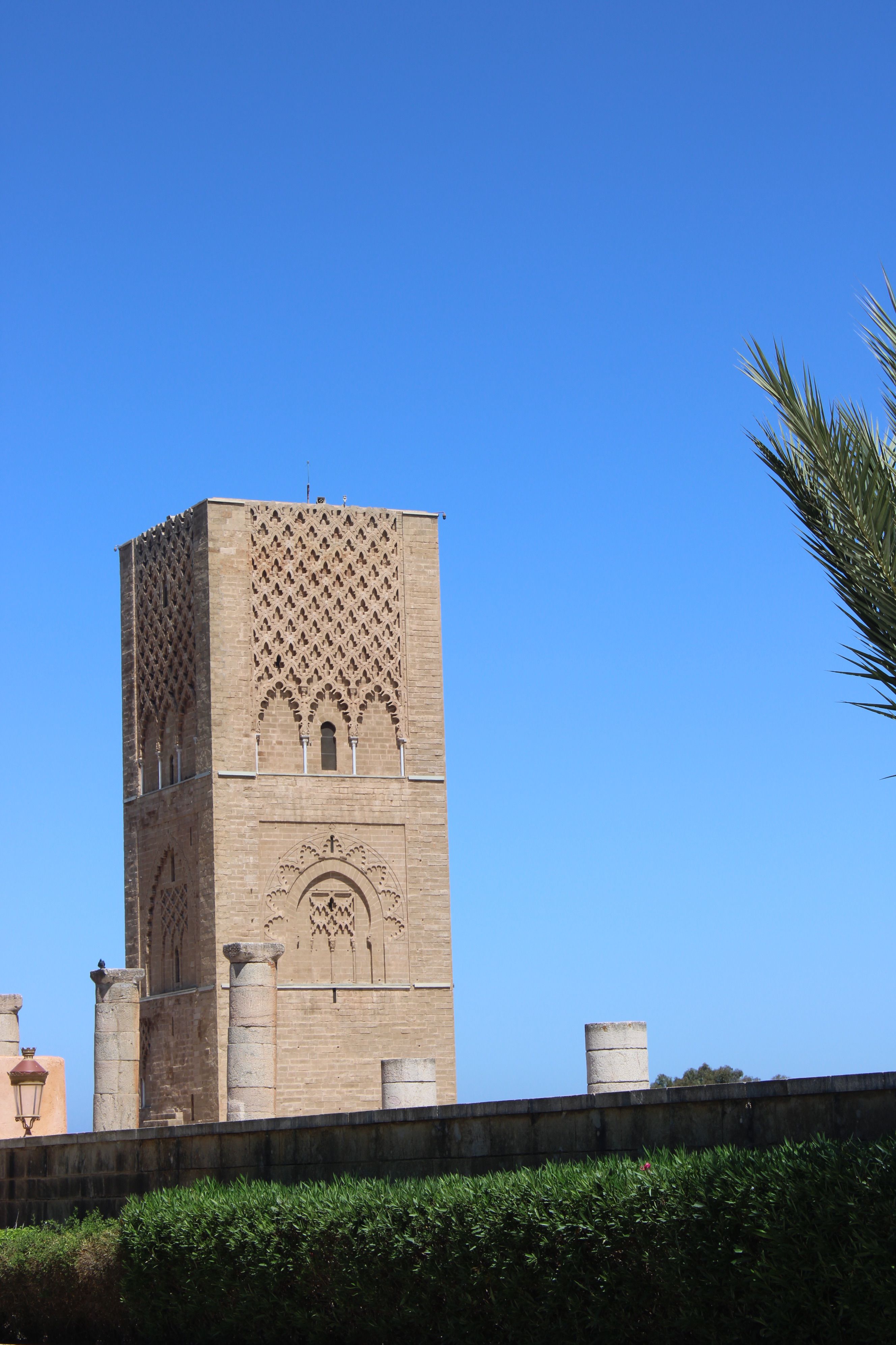 The iconic Hassan Tower in Rabat, Morocco, stands tall under a vivid blue sky.