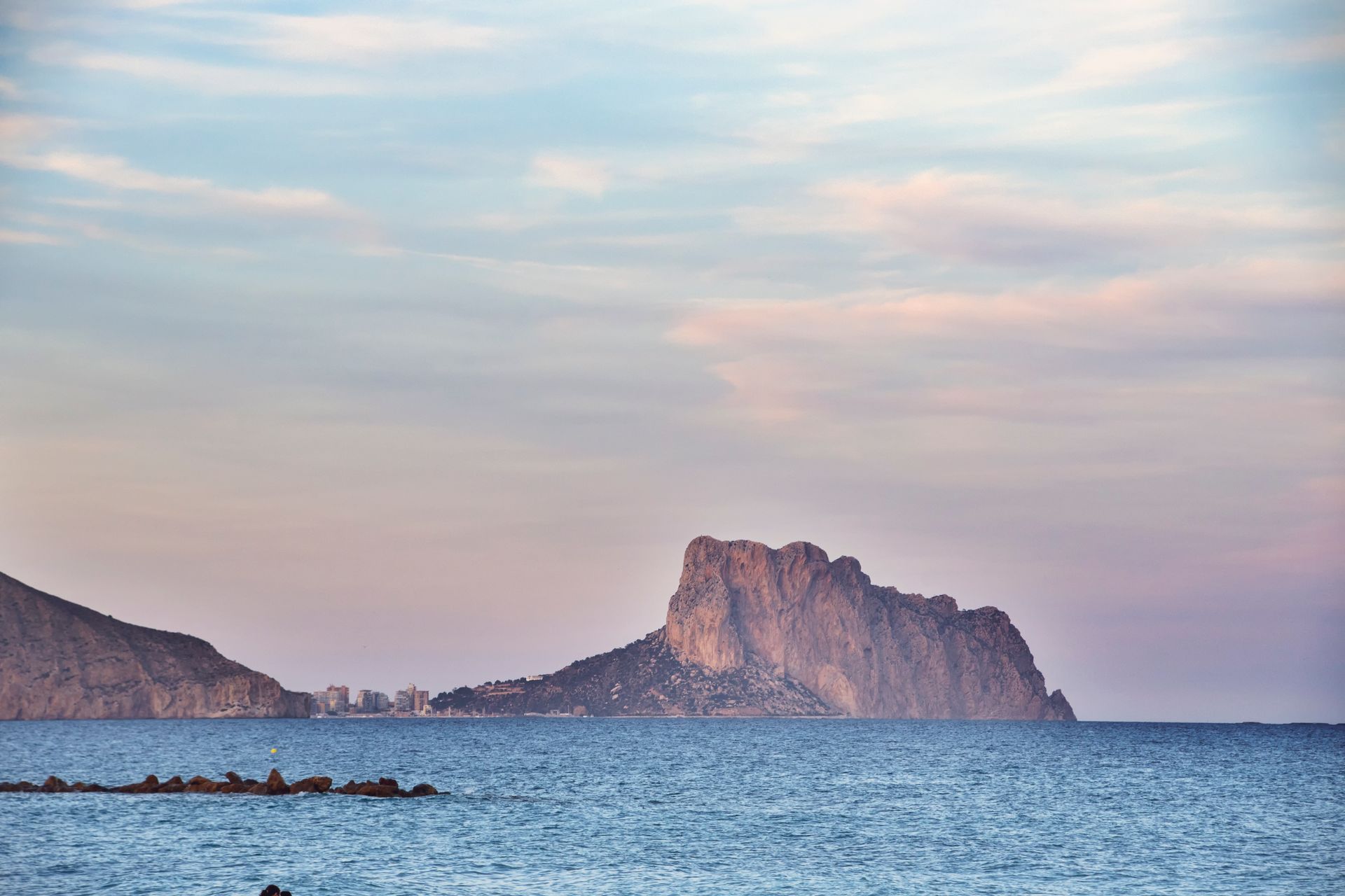Breathtaking coastal landscape with prominent rock formations under a pastel sky.