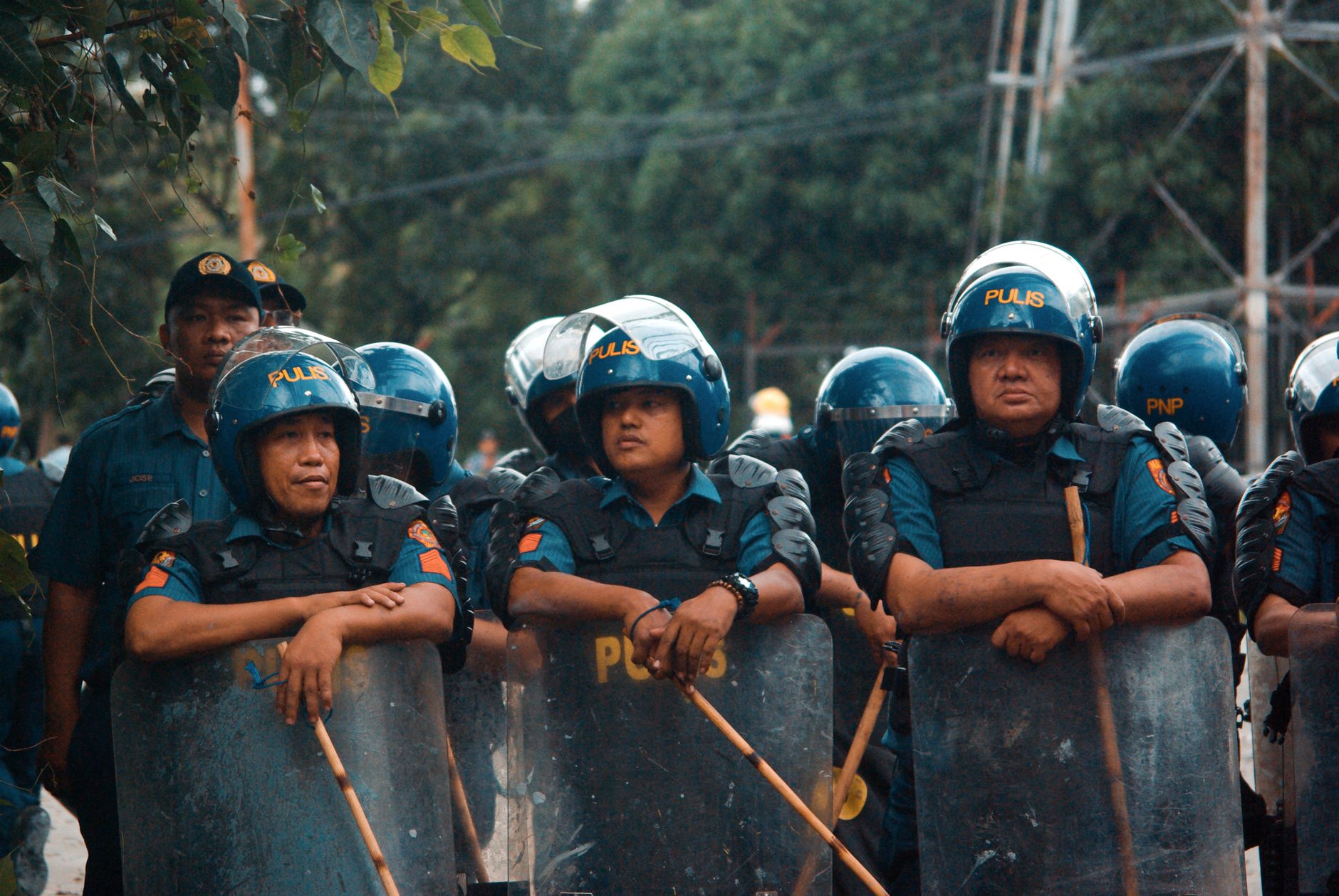 Malaysian police officers securing a rural Penampang house after a reported illegal cockfighting raid