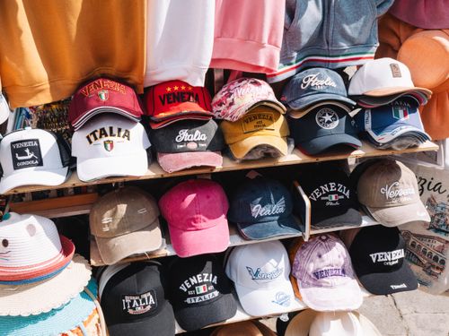 Free Assortment of colorful Venezia and Italia caps on display in Venice, Italy market. Stock Photo