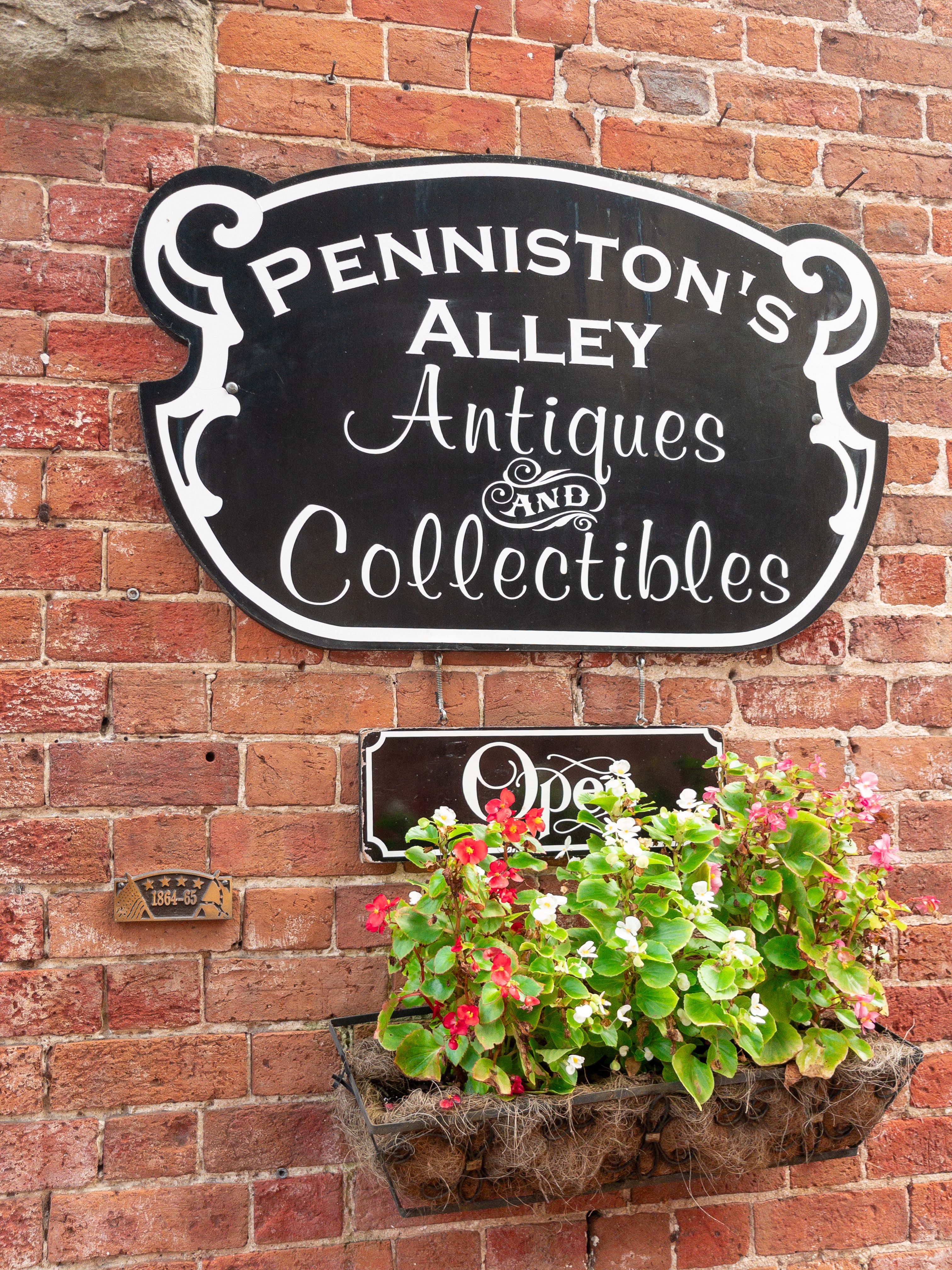 Charming Antique Storefront Sign on Brick Wall · Free Stock Photo