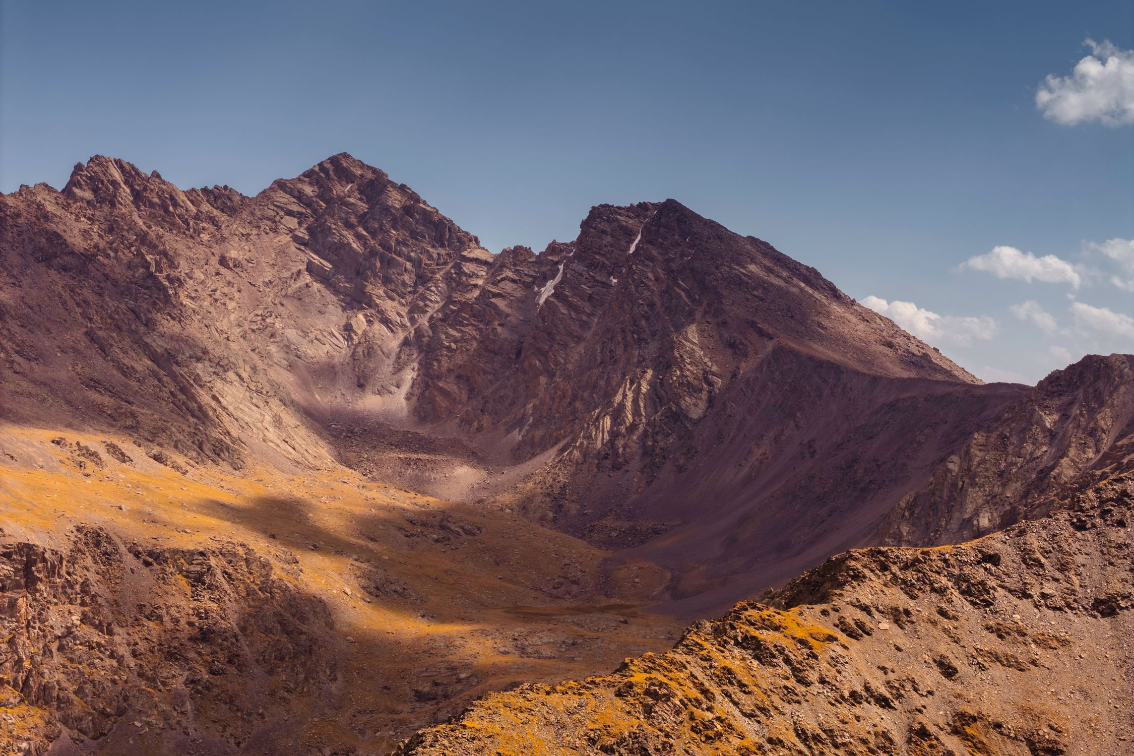 Photo by Aloha Photo Studio Rugged mountain peaks under clear blue sky in Kyrgyzstan