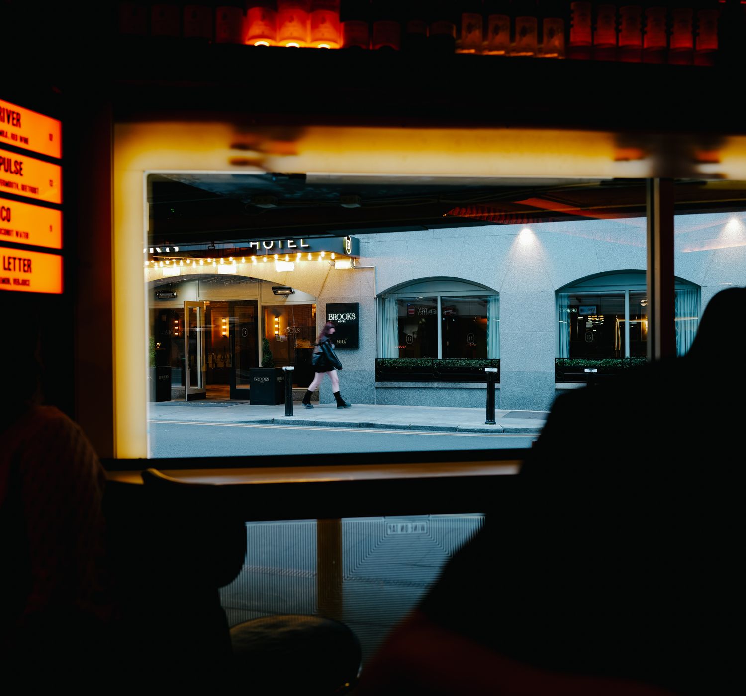Dimly lit bar at Emberline looking out to the King West street