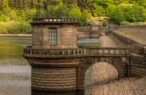 Free Stone tower structure in a lush English landscape reservoir setting. Stock Photo