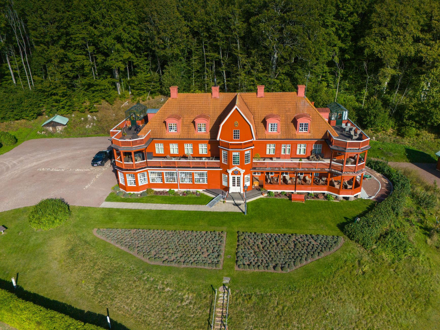 Discover a picturesque Swedish manor surrounded by lush greenery, captured in summer.