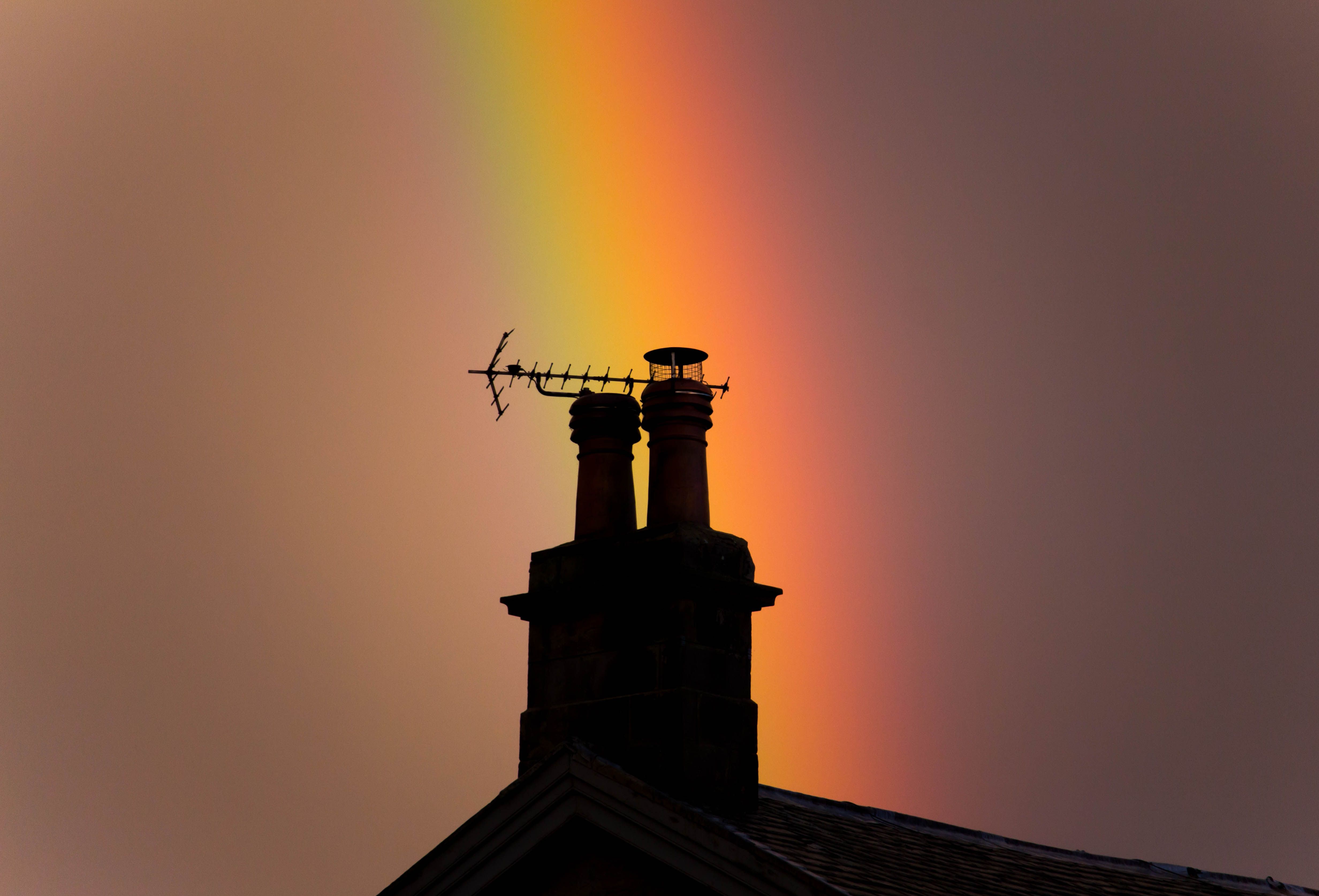 Chimney Silhouette Against Vibrant Rainbow Sky · Free Stock Photo
